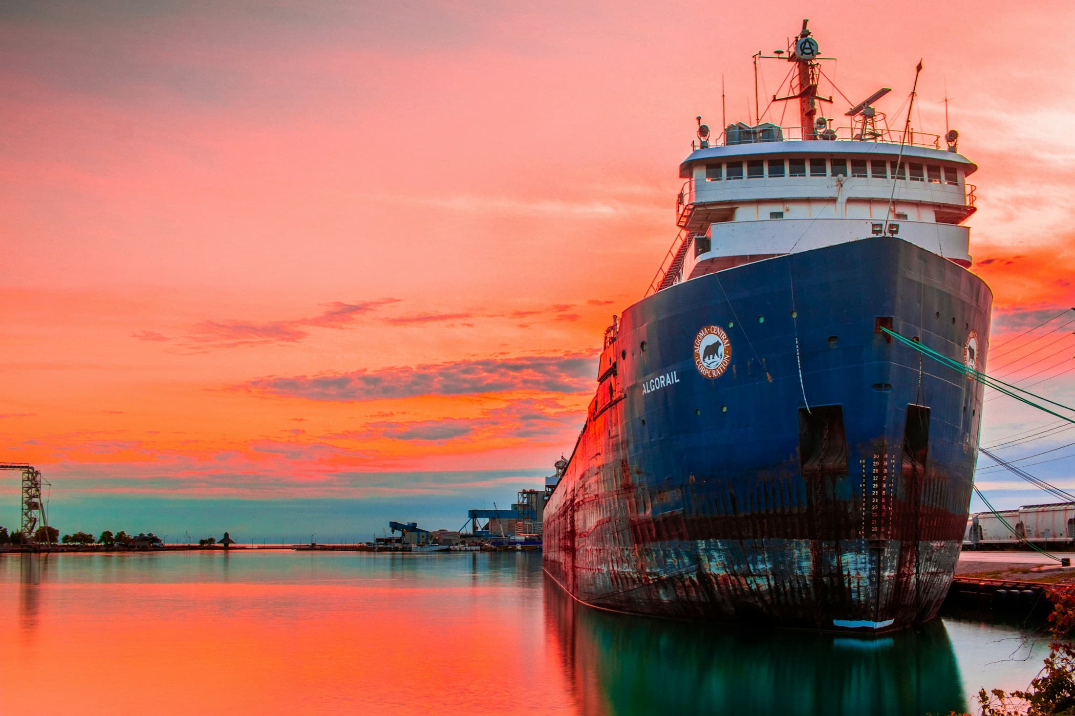Cargo vessel moored at an industrial port at dusk